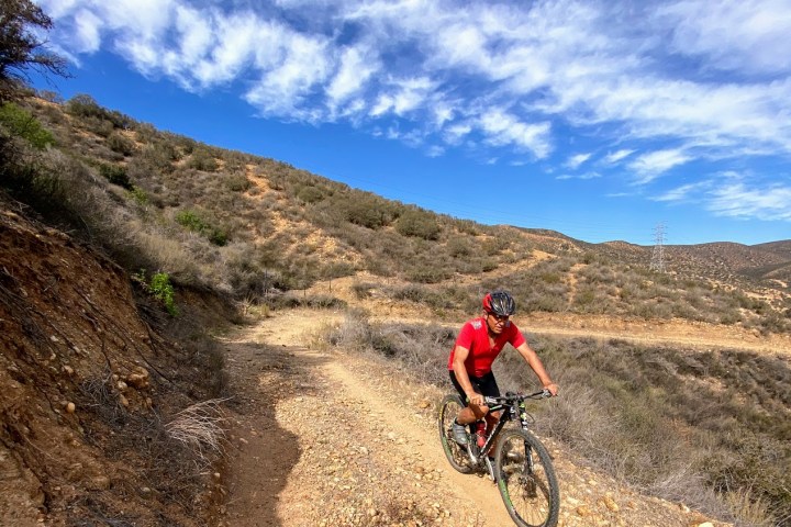 a man riding a bike down a dirt road